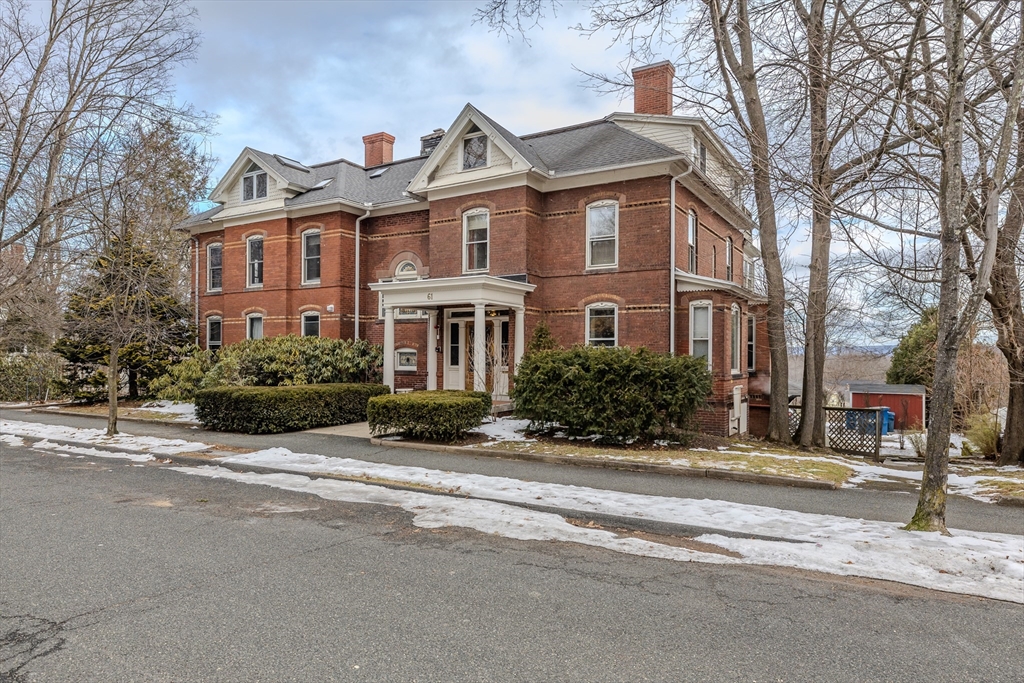 61 Crescent Street, Unit 8 Northampton, MA 01060 - Photo 3 of 30 a front view of a house with a yard and a garage