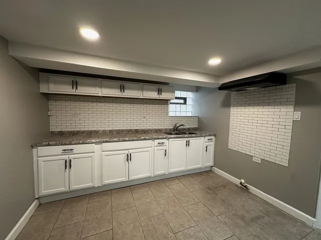 a kitchen with granite countertop a sink and cabinets