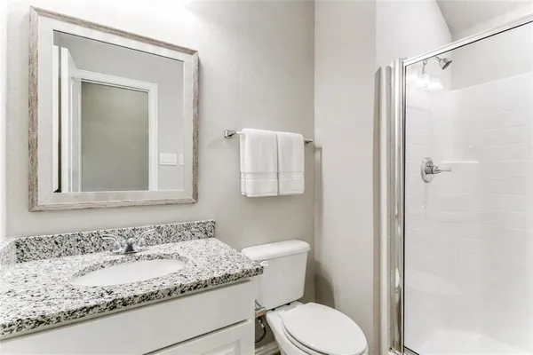 a bathroom with a granite countertop sink toilet and shower