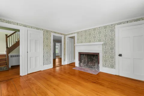 wooden floor fireplace and windows in an empty room