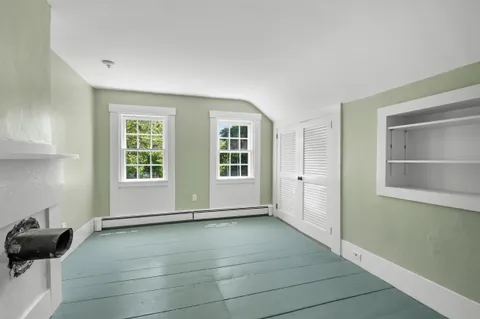 a view of a yard in front of a house with plants and large tree