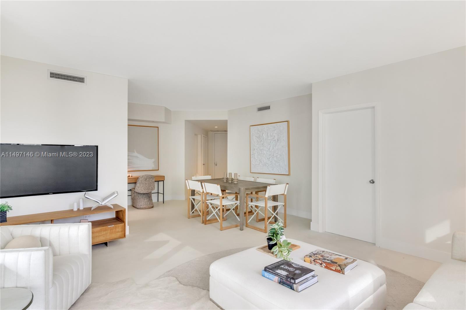 801 Brickell Key Boulevard, Unit 1102 Miami, FL 33131 - Photo 4 of 15 a living room with furniture and a flat screen tv