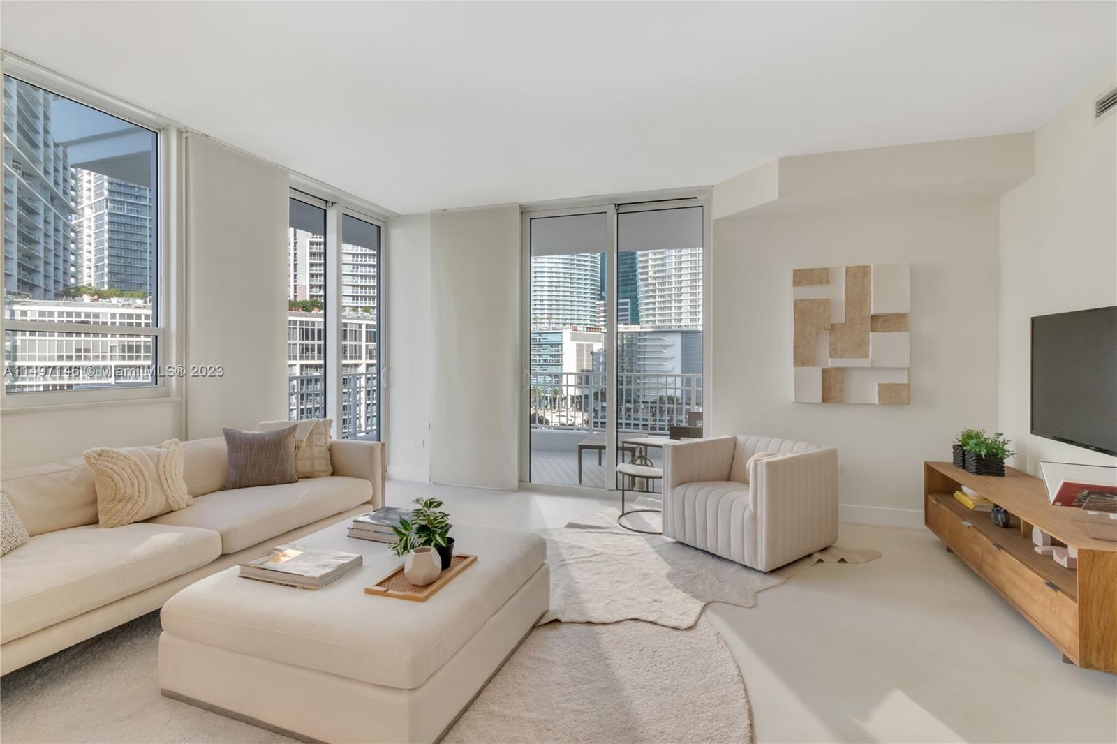 801 Brickell Key Boulevard, Unit 1102 Miami, FL 33131 - Photo 10 of 15 a living room with furniture and floor to ceiling windows