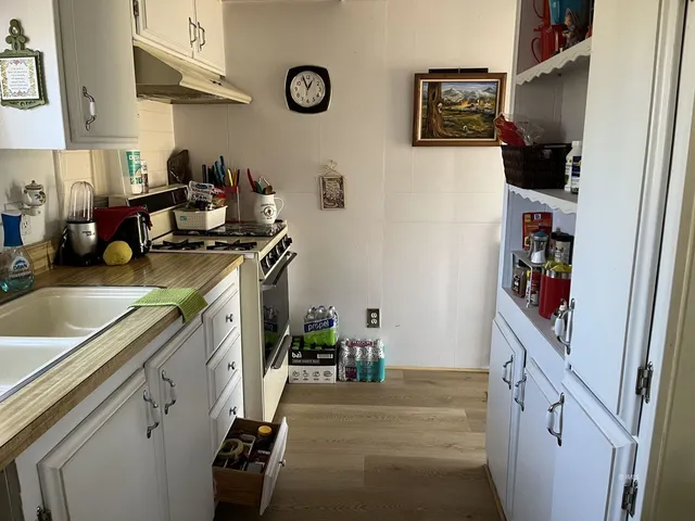 a kitchen with stainless steel appliances granite countertop a sink stove and cabinets