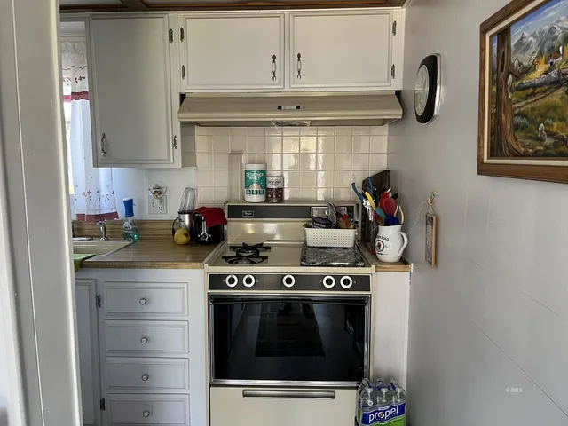 a stove top oven sitting inside of a kitchen