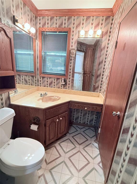 160 Bob White Road Denison, TX 75020 - Photo 20 of 29 Bathroom featuring a corner vanity with a built-in sink, wood-finish cabinetry, and a countertop