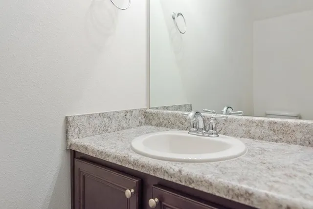 a bathroom with a granite countertop sink and a mirror
