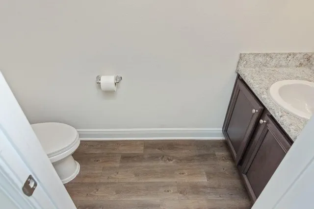 a bathroom with a granite countertop toilet and a sink