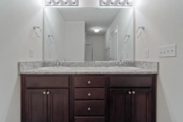 a bathroom with a granite countertop sink a large mirror and a vanity