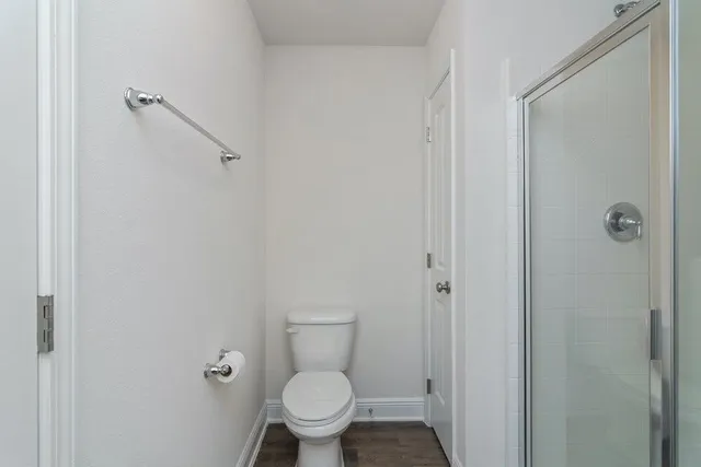 a bathroom with a granite countertop toilet and a shower