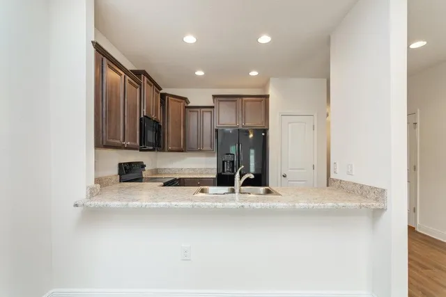 a view of a kitchen with a sink and a refrigerator