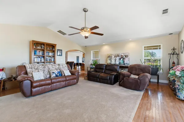 a living room with furniture ceiling fan and a rug