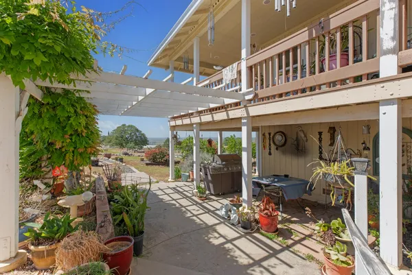a view of a balcony with chairs and potted plants