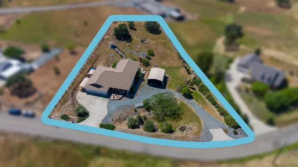 an aerial view of a house a yard and a lake view