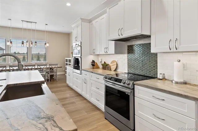 a kitchen with granite countertop a sink a stove and cabinets
