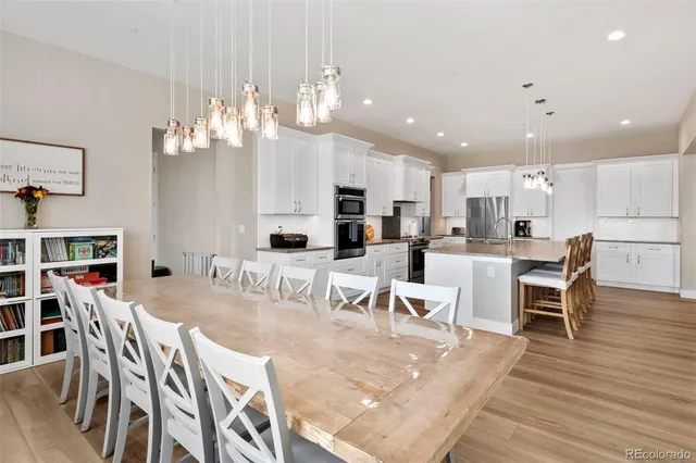 a view of a dining room and livingroom with furniture wooden floor a chandelier