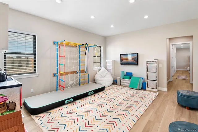 a bedroom with a bed a couch and a flat tv screen next to a window