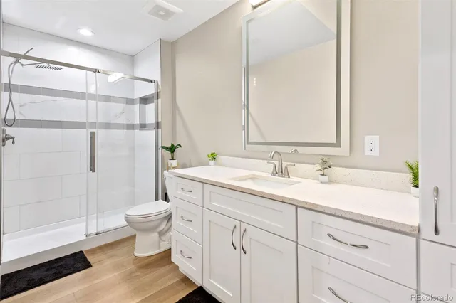 a bathroom with a double vanity sink toilet and shower