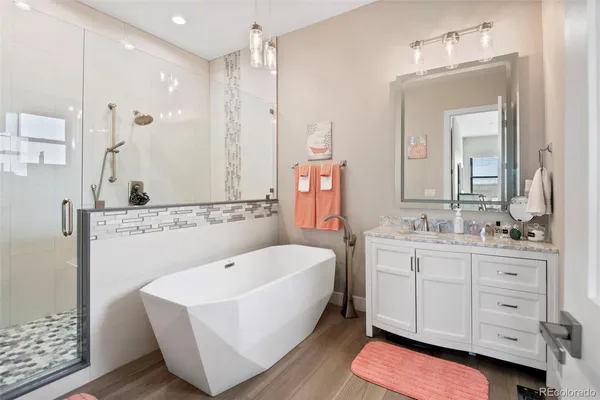 a bathroom with a double vanity sink mirror and bathtub
