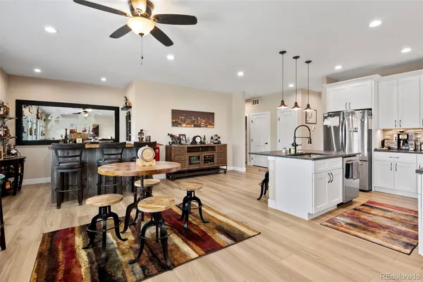 a living room with lots of furniture and kitchen view