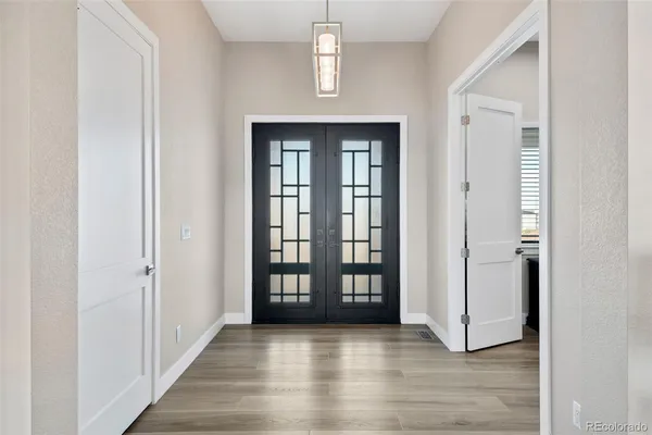 an empty room with wooden floor windows and hallway