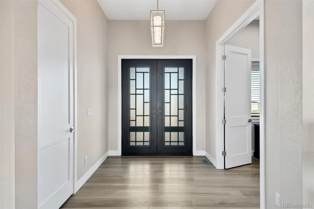 an empty room with wooden floor windows and hallway