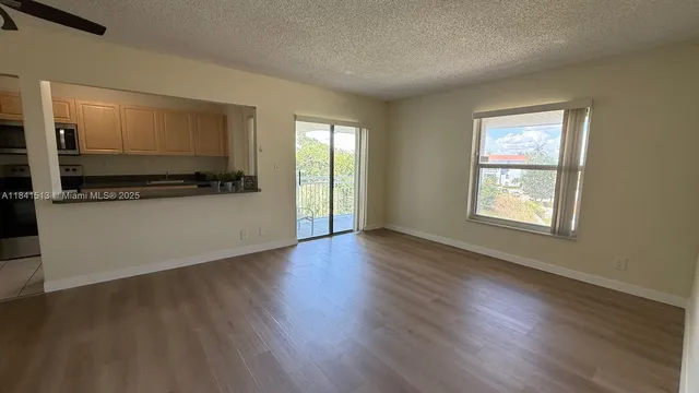 a view of a kitchen with wooden floor and electronic appliances