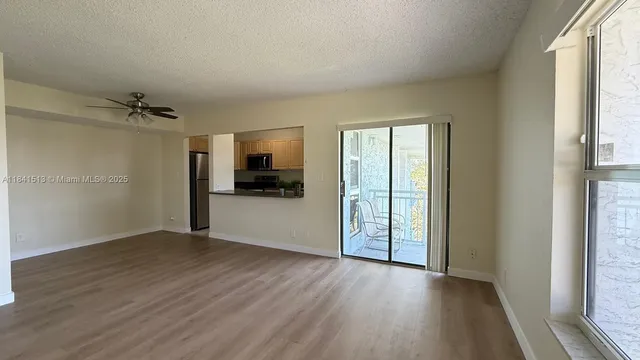 a view of empty room with wooden floor and window