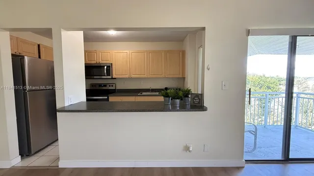 a kitchen with stainless steel appliances granite countertop a refrigerator and a stove