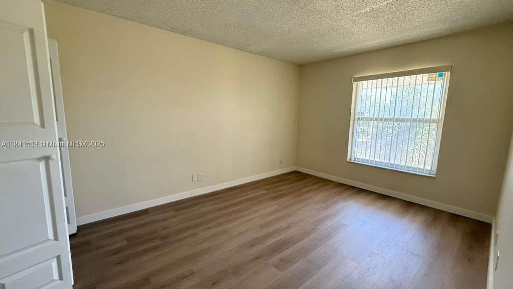 605 South Pine Island Road, Unit 405A Plantation, FL 33324 - Photo 8 of 17 an empty room with wooden floor and windows