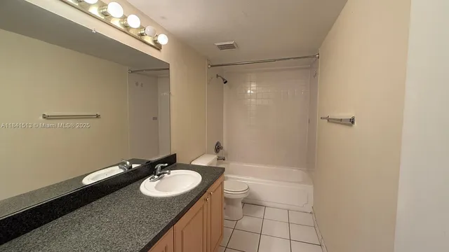 a bathroom with a granite countertop sink a mirror and a shower
