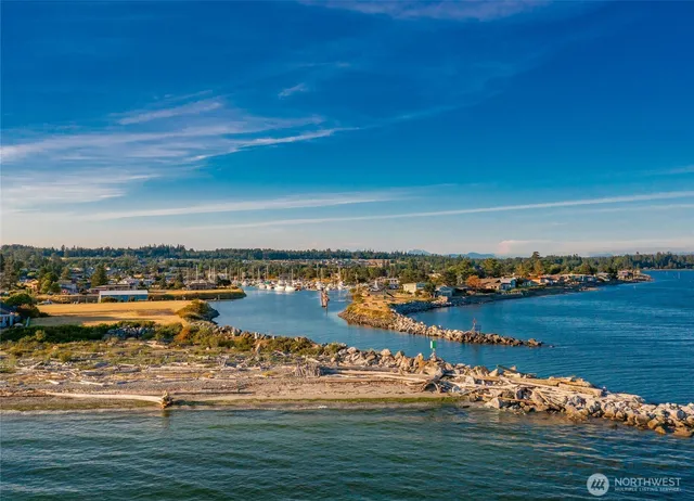 an aerial view of a city with lots of residential buildings ocean and mountain view in back