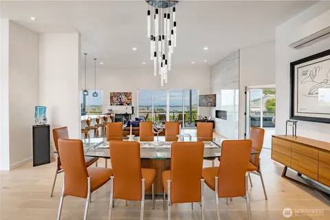 a kitchen with stainless steel appliances kitchen island granite countertop a refrigerator a stove a kitchen island a dining table and chairs