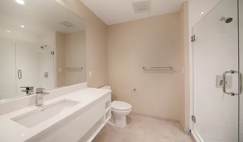 a bathroom with a sink a toilet and shower