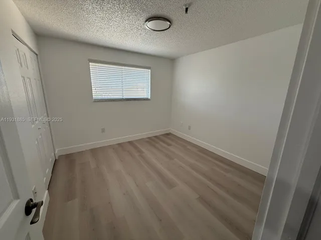 a view of a room with wooden floor and windows