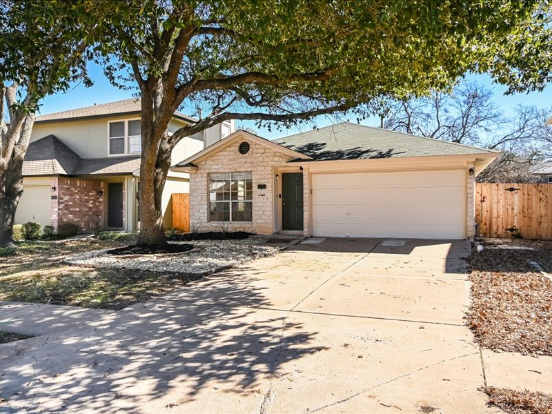 View of front of house with an attached garage, driveway, and roof with shingles