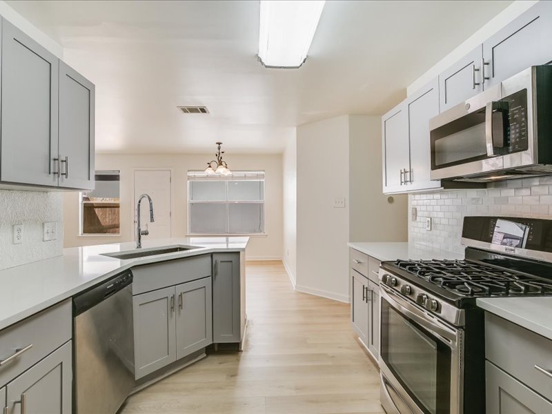 817 Smoke Signal Pass Pflugerville, TX 78660 - Photo 4 of 10 Kitchen with gray cabinets, decorative backsplash, and stainless steel appliances