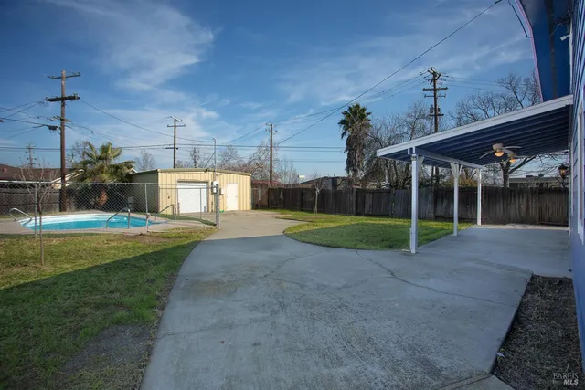 a view of a house with swimming pool and a yard