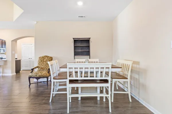 a dining room with furniture and wooden floor
