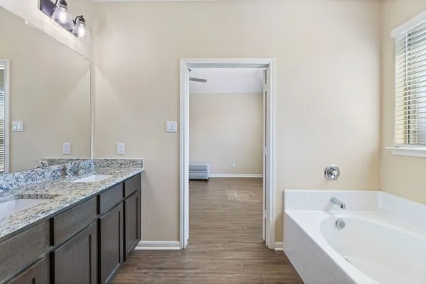 a bathroom with a tub sink and mirror
