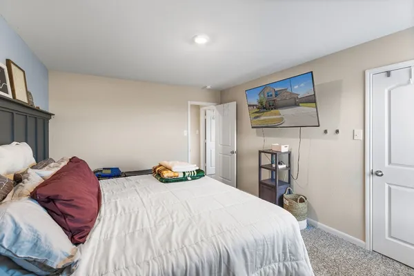 a bedroom with a bed and a painting on the wall