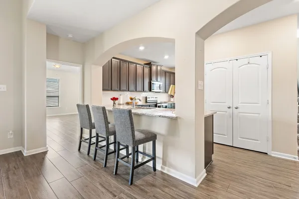 a kitchen with kitchen island granite countertop wooden floors and white cabinets