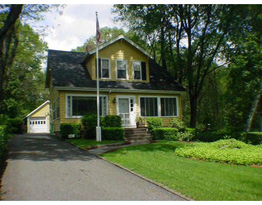 63 Spring Street Lexington, MA 02421 - Photo 1 of 14 a front view of a house with a yard and trees