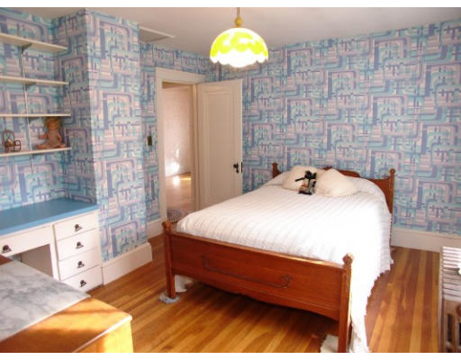 63 Spring Street Lexington, MA 02421 - Photo 8 of 14 a bedroom with a bed and a chandelier