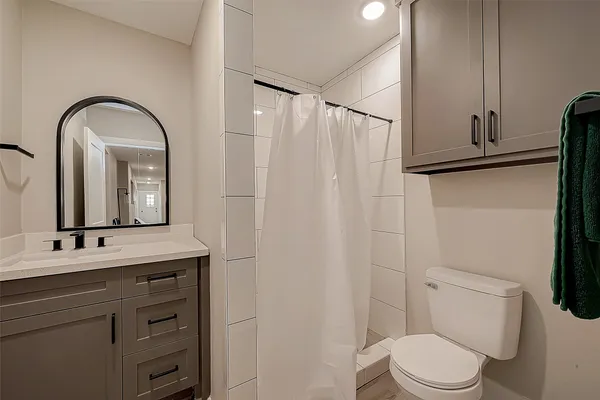 a bathroom with a toilet a sink and mirror