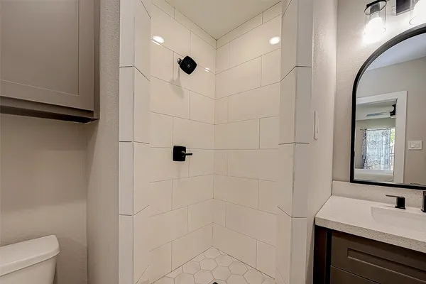 a bathroom with a sink a toilet and shower