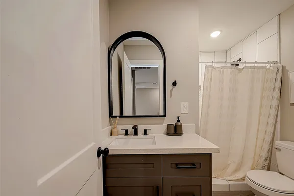 a bathroom with a sink a toilet and shower