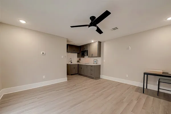 a view of a room with a sink and wooden floor