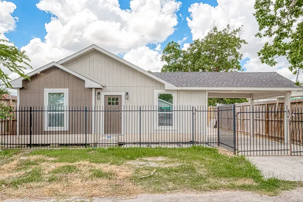 a white house that has tree in front of it