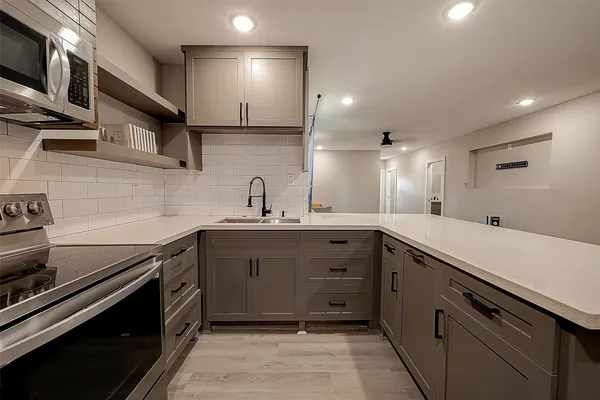 a kitchen with stainless steel appliances a sink stove and cabinets
